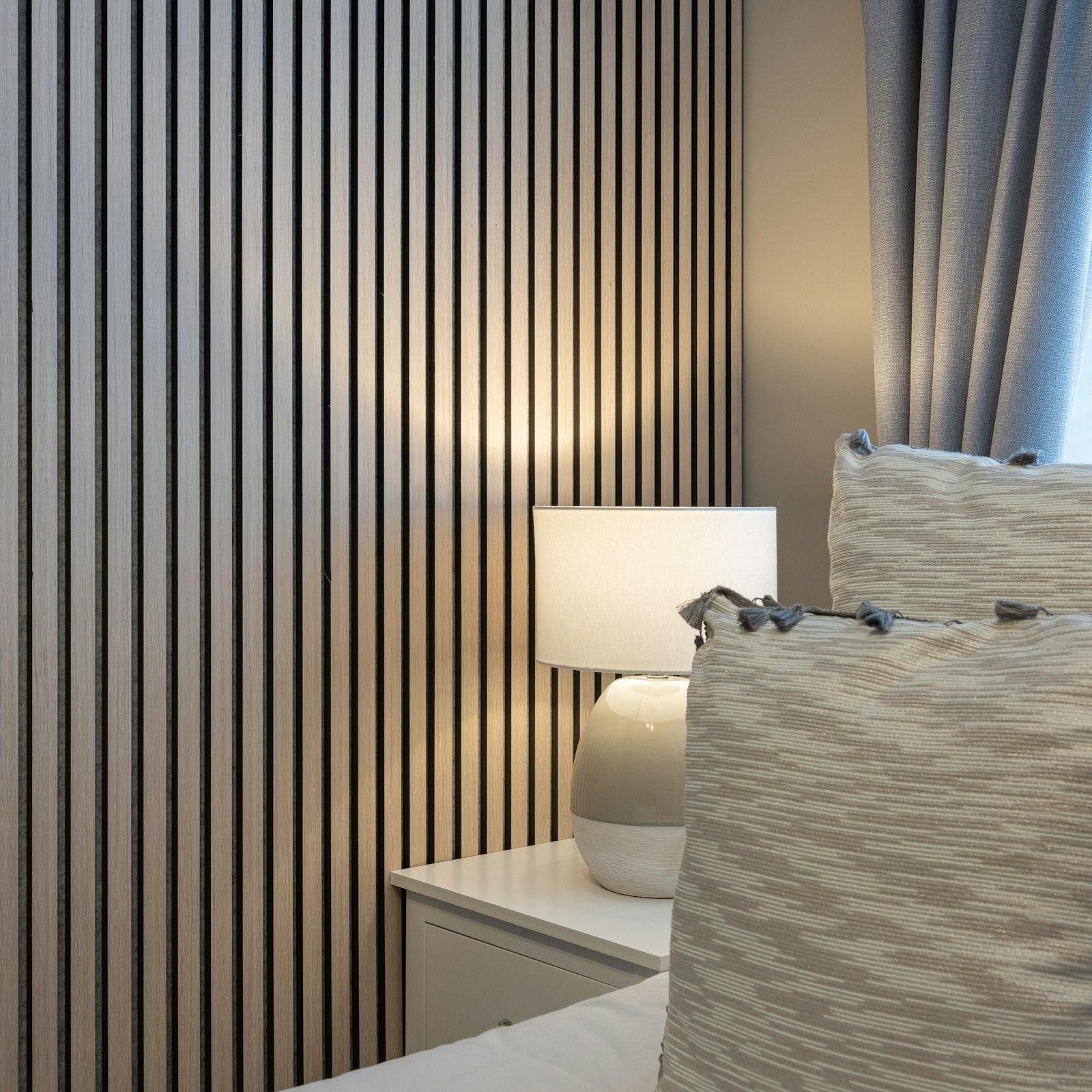 Slatted acoustic wall panelling beside a bed