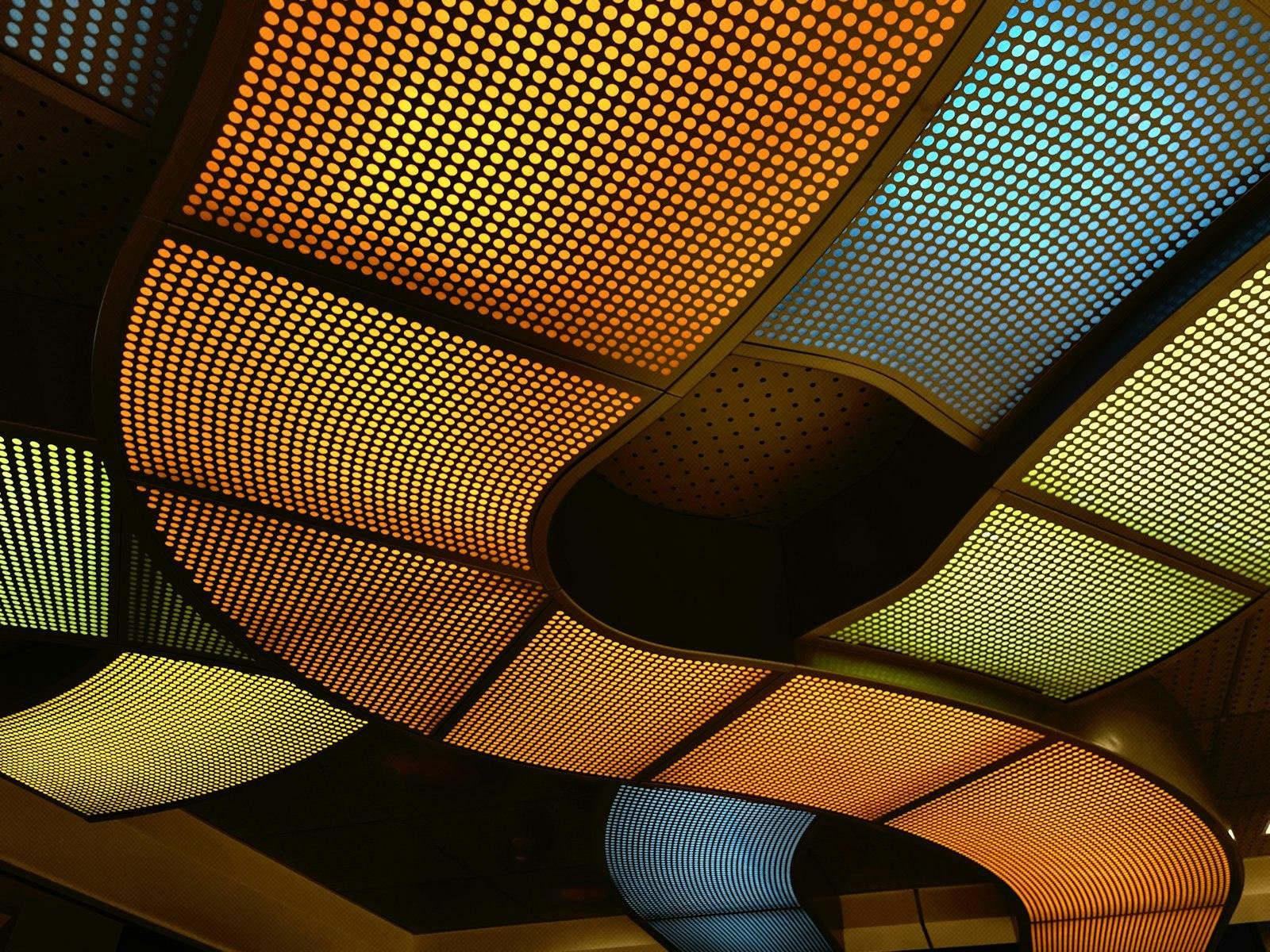 Backlit stretch ceiling in colour, curving across a public space